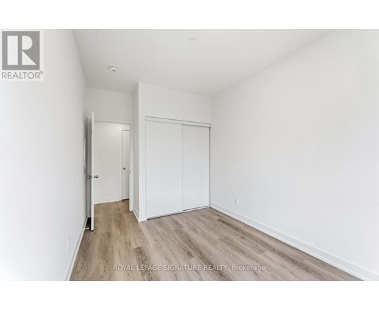 A white room with a sliding door and wooden flooring.