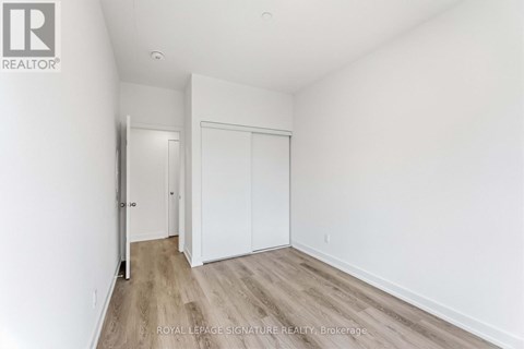 A white room with a sliding door and wooden flooring.