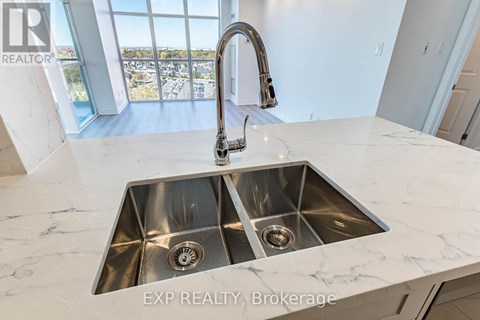 A modern kitchen with a double sink and a large window.