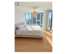 A bedroom with a large bed and a view of the city.