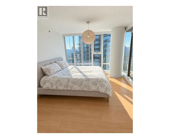 A bedroom with a large bed and a view of the city.