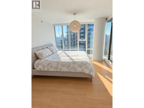 A bedroom with a large bed and a view of the city.