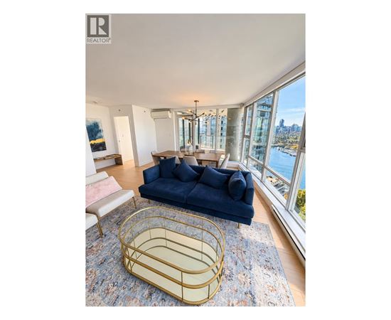 A blue sofa sits in a living room with a view of the city.