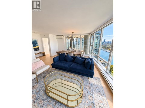 A blue sofa sits in a living room with a view of the city.