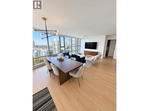 A modern dining room with a long table and chairs.