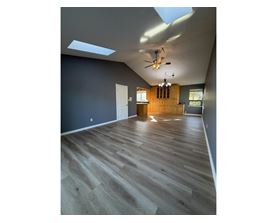 A room with wooden flooring and a skylight.