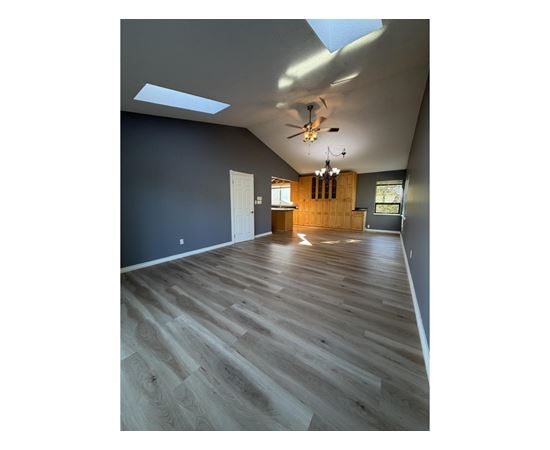 A room with wooden flooring and a skylight.