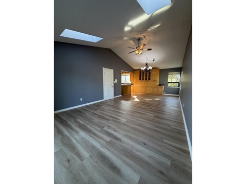 A room with wooden flooring and a skylight.
