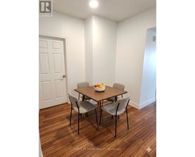 A dining room with a table and chairs.
