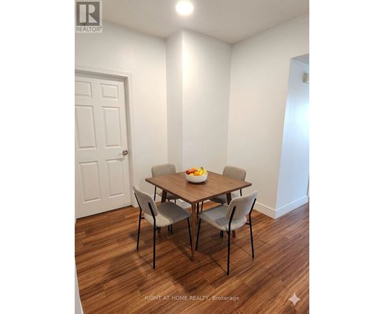 A dining room with a table and chairs.