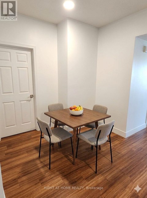 A dining room with a table and chairs.
