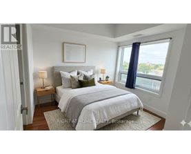 A bedroom with a large bed and a window overlooking the city.