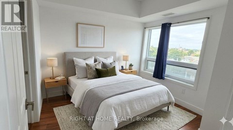 A bedroom with a large bed and a window overlooking the city.