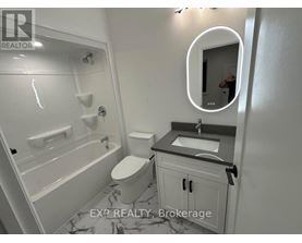 A bathroom with a toilet, sink, and bathtub.