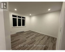 A room with a window and wooden flooring.