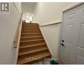 A wooden staircase with a white door on the side.