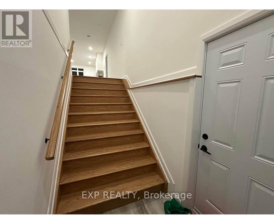 A wooden staircase with a white door on the side.