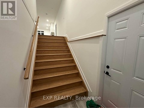 A wooden staircase with a white door on the side.