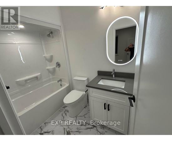 A bathroom with a toilet, sink, and bathtub.