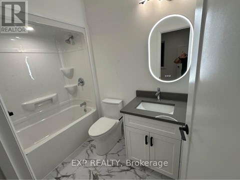 A bathroom with a toilet, sink, and bathtub.