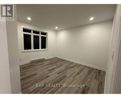 A room with a window and wooden flooring.