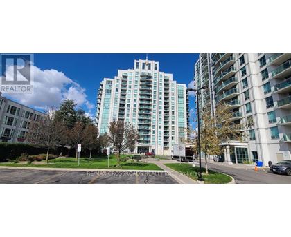 A tall building with a glass facade stands in front of a smaller building with a white facade.