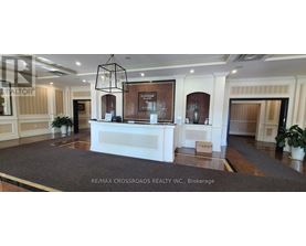 A reception area with a white reception desk and a brown carpet.