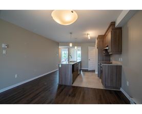 A kitchen with wooden floors and cabinets.