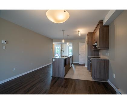 A kitchen with wooden floors and cabinets.