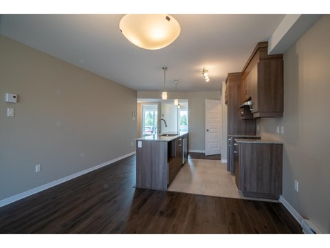 A kitchen with wooden floors and cabinets.