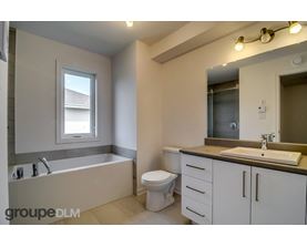A bathroom with a tub, toilet, and sink.