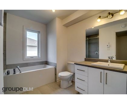 A bathroom with a tub, toilet, and sink.