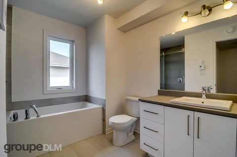 A bathroom with a tub, toilet, and sink.