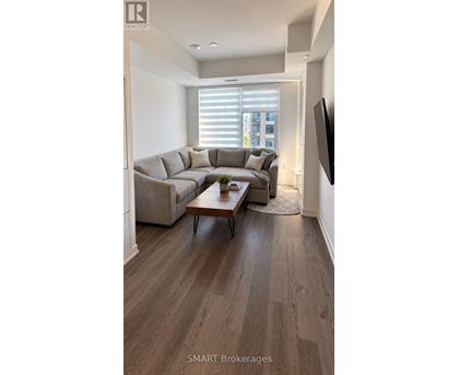 A living room with a grey couch and a wooden coffee table.
