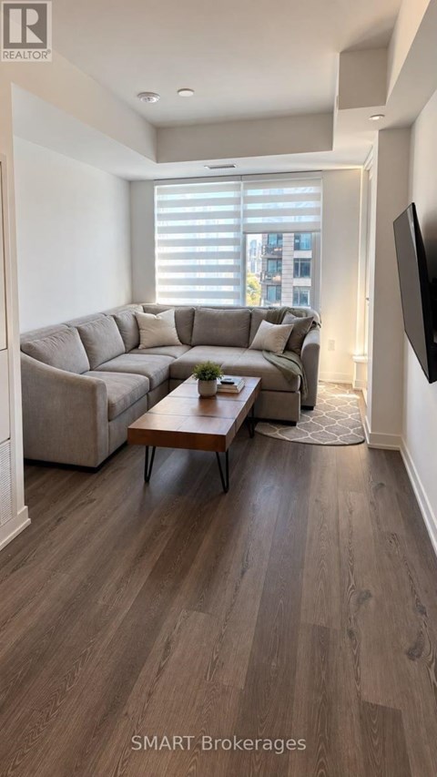A living room with a grey couch and a wooden coffee table.