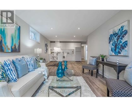 A modern living room with a glass coffee table and a blue vase on it.