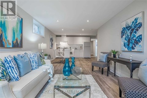 A modern living room with a glass coffee table and a blue vase on it.