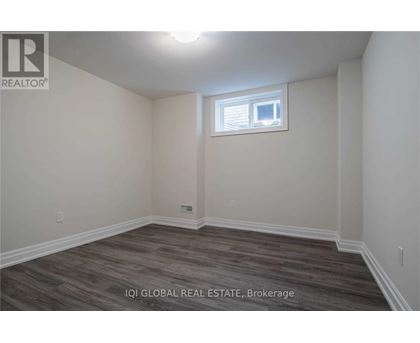 A room with a window and wooden flooring.
