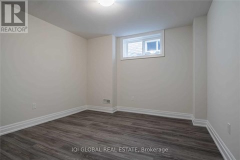 A room with a window and wooden flooring.