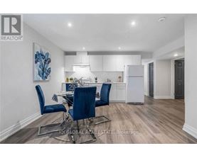 A modern kitchen with a dining table set up with blue chairs.