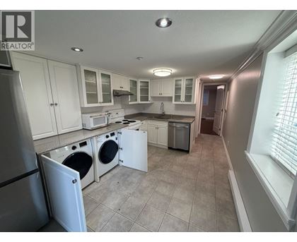 A kitchen with white cabinets and appliances.