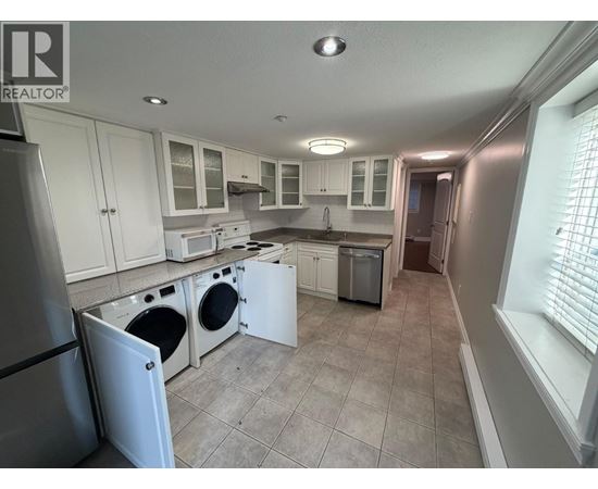 A kitchen with white cabinets and appliances.