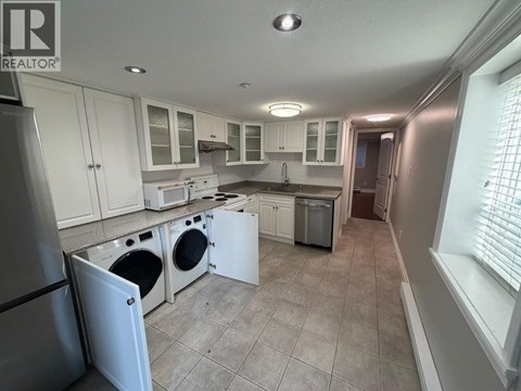 A kitchen with white cabinets and appliances.