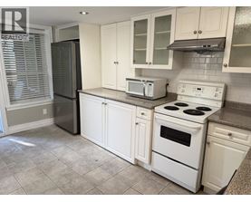 A kitchen with white appliances and cabinets.