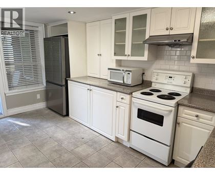 A kitchen with white appliances and cabinets.