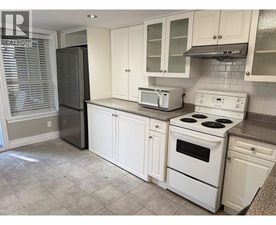 A kitchen with white appliances and cabinets.