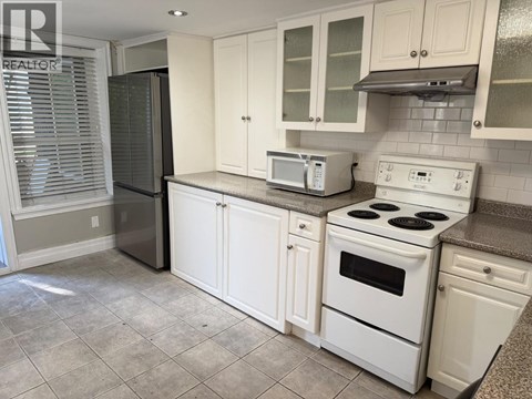 A kitchen with white appliances and cabinets.