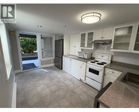 A kitchen with white appliances and cabinets.