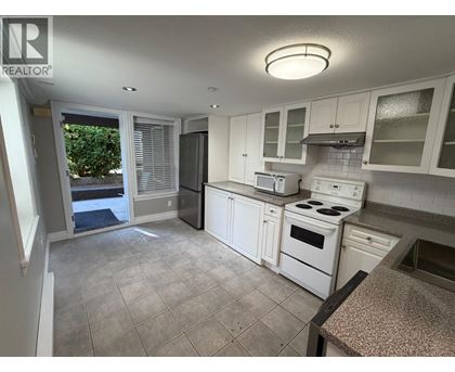 A kitchen with white appliances and cabinets.