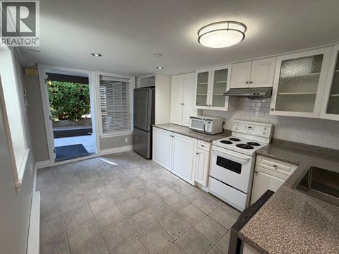 A kitchen with white appliances and cabinets.